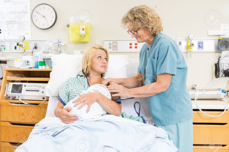 23728997-smiling-mature-nurse-assisting-woman-in-breast-feeding-newborn-baby-in-hospital-room-stock-photo